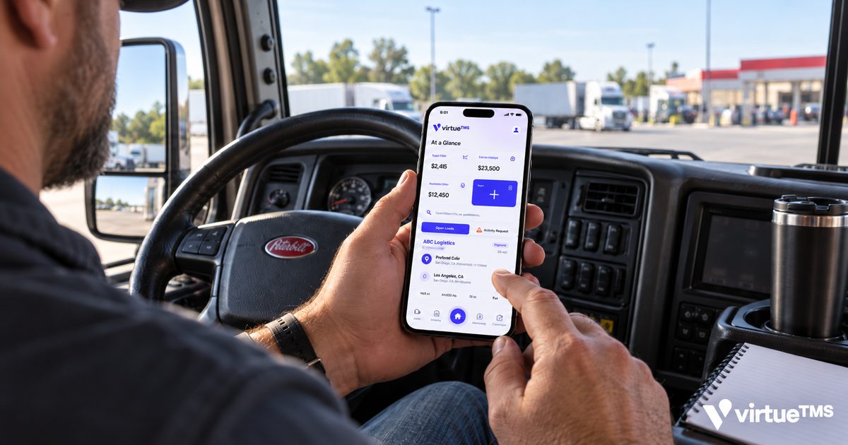 An owner-operator in the cab of his truck, checking the VirtueTMS app on his phone at a truck stop